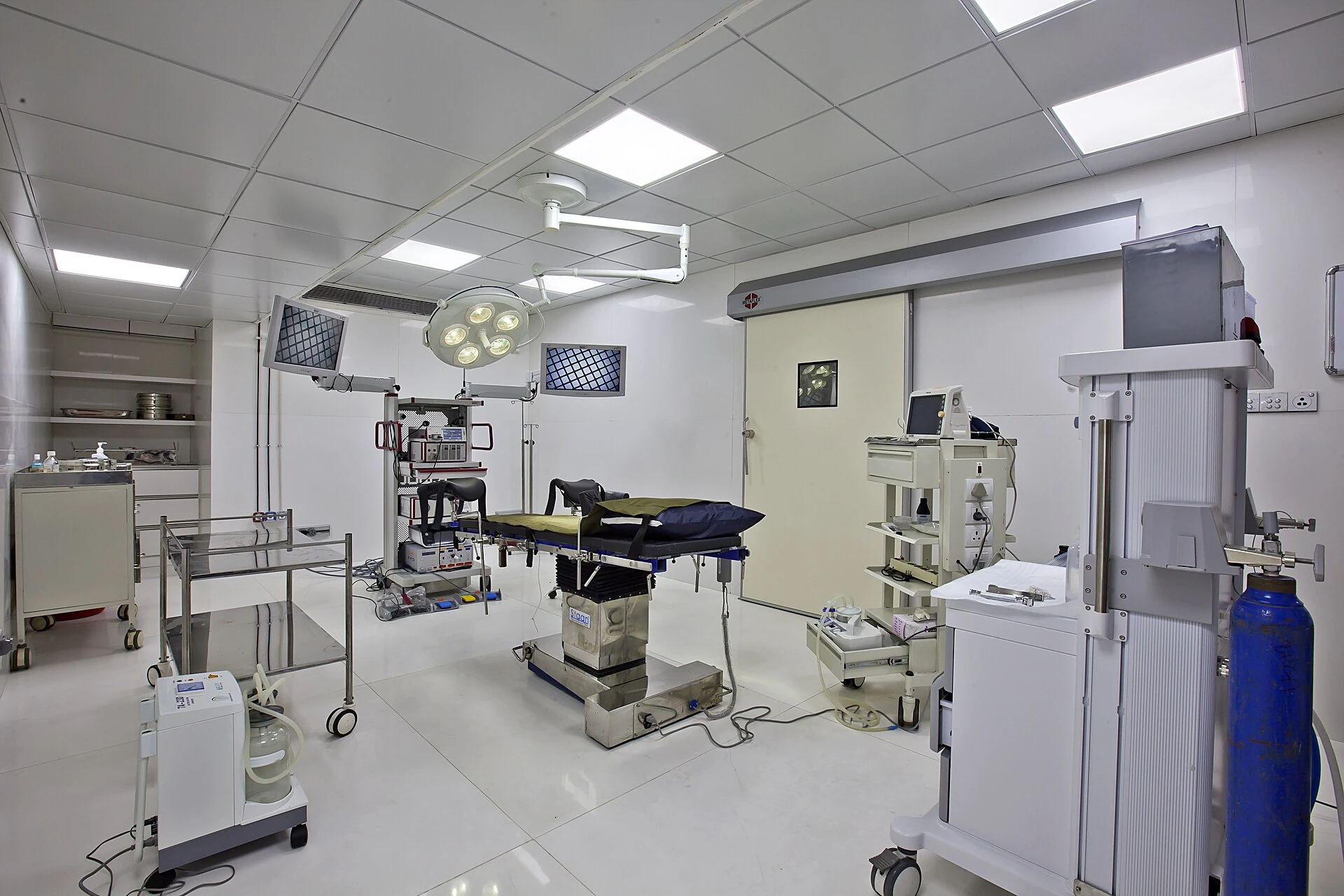 Modern hospital operating room with surgical light and equipment carts
