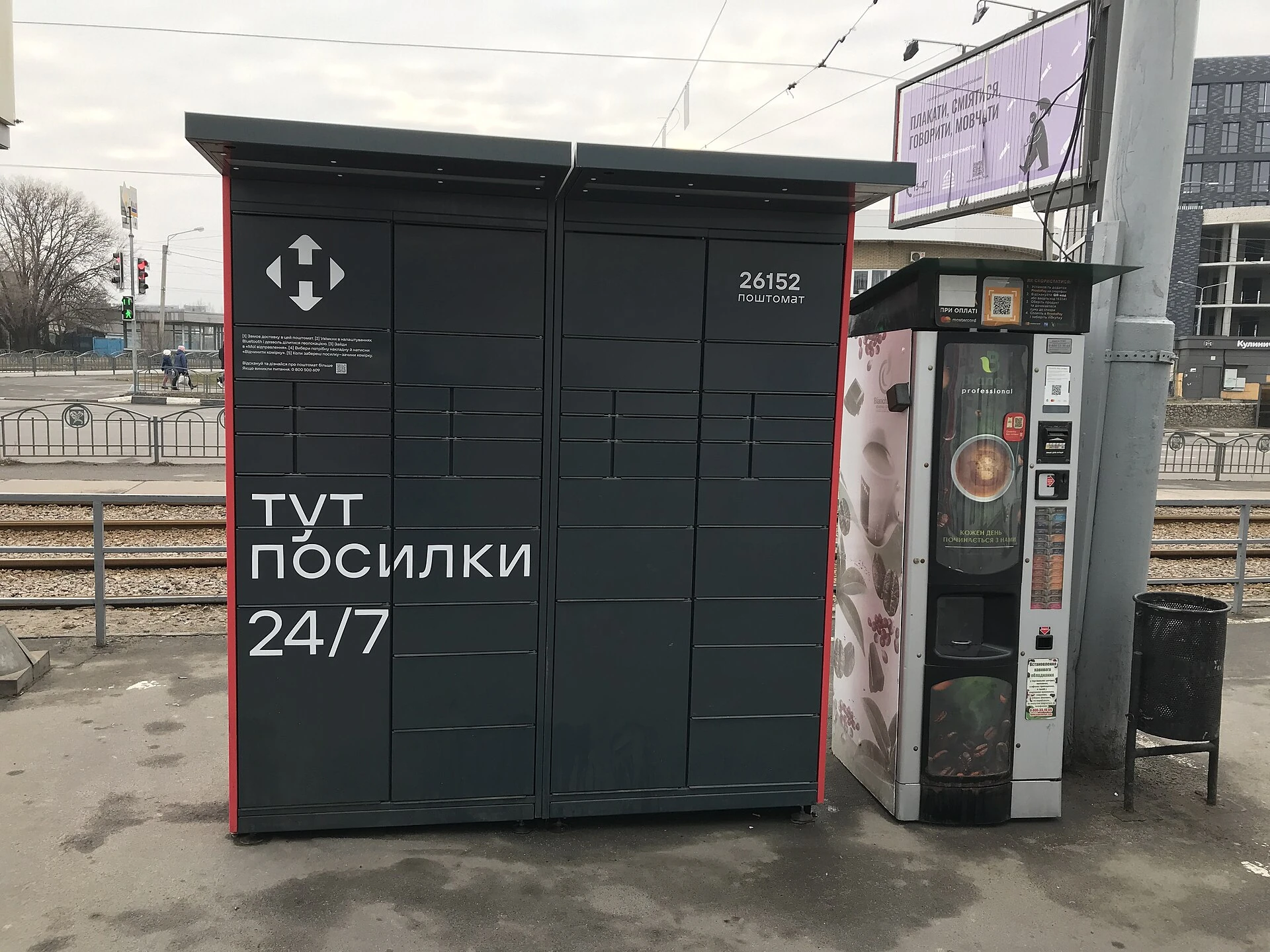 Outdoor self-service parcel locker bank installed next to a transit stop